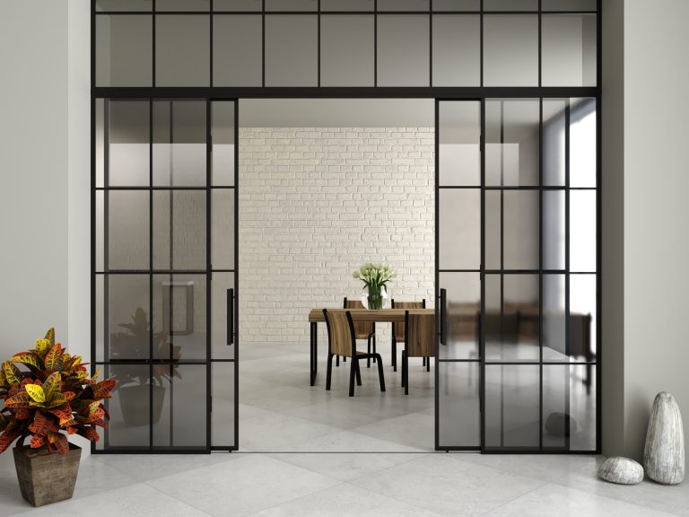 Grey toughened glass doors in black steel frames leading to a dining space